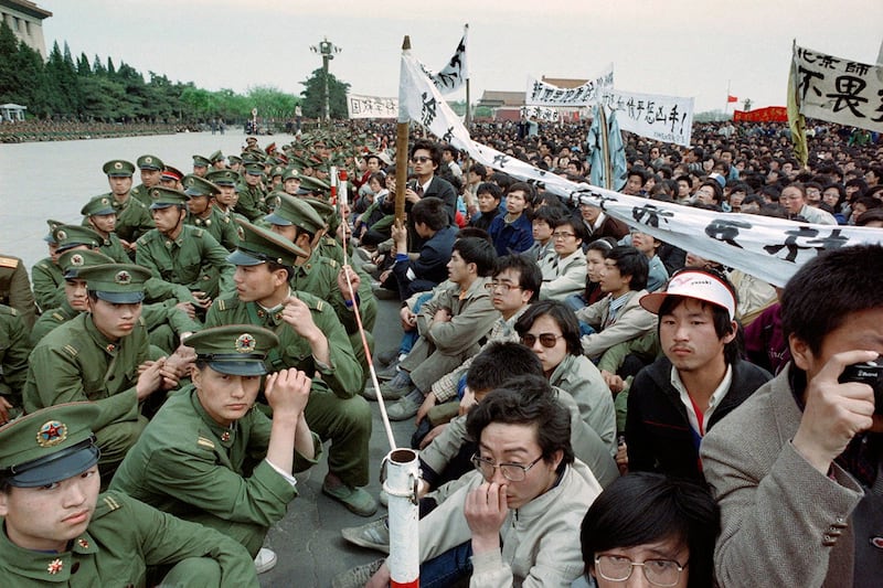 1989年4月22日，在天安门广场，学生抗议者面对军警，哀悼前共产党领导人中的自由派胡耀邦的去世。（法新社）