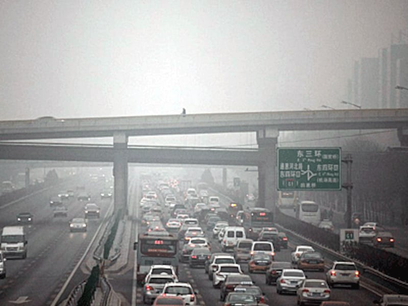 A man (top C) walks along an overpass amid heavy smog in Beijing during the Chinese capital's first-ever red alert for air pollution, Dec. 8, 2015.