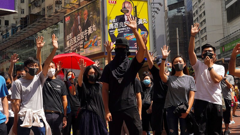 2019年10月4日，香港抗议者戴着口罩并举起张开手掌的单手，代表五大诉求。（美联社）