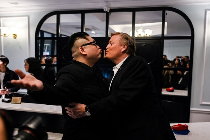 Ông Howard X (trái) đóng giả Chủ tịch Kim Jong Un và ông Russel White đóng giả Tổng thống Donald Trump hôn nhau tại khách sạn La Paix ở Hà Nội sáng ngày 25/2/2019