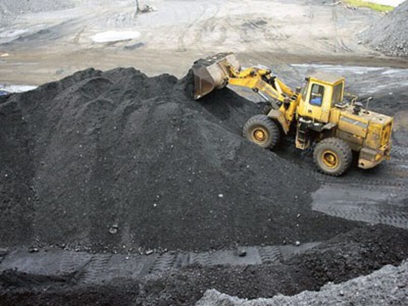 A wheel loader piles up coal at a coalyard in Yichang, central China's Hubei province, Sept. 12, 2016.