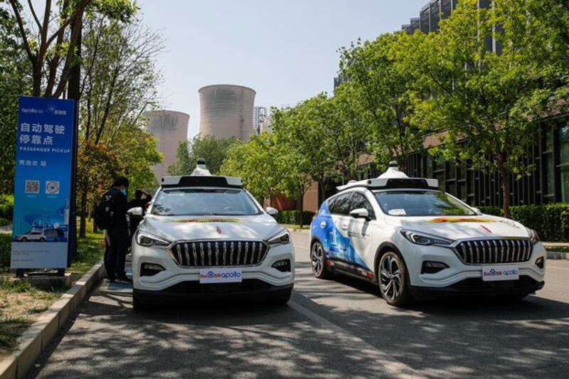 Baidu Apollo robotaxis pass a passenger pickup point at Shougang Park in Beijing, China, May 2, 2021. (Andy Wong/AP)