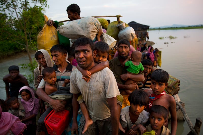 Rohingya carry their young children and belongings after crossing the border from Myanmar into Bangladesh, near Palong Khali, Bangladesh, Nov. 1, 2017.