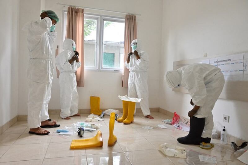 Doctors and nurses put on protective equipment before entering a quarantine facility for COVID-19 patients in Tangerang, Banten province, Indonesia, June 22, 2020. (Adek Berry/AFP)