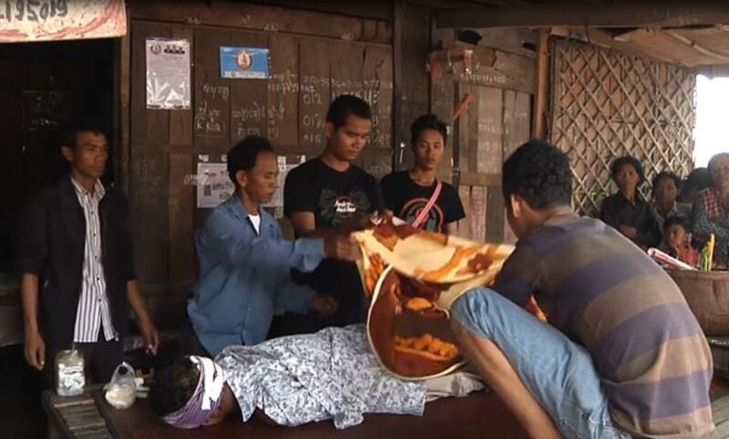 Villagers prepare the body of CNRP activist Sann Soeung before placing it into a coffin in Kompong Speu, Aug. 13, 2013.