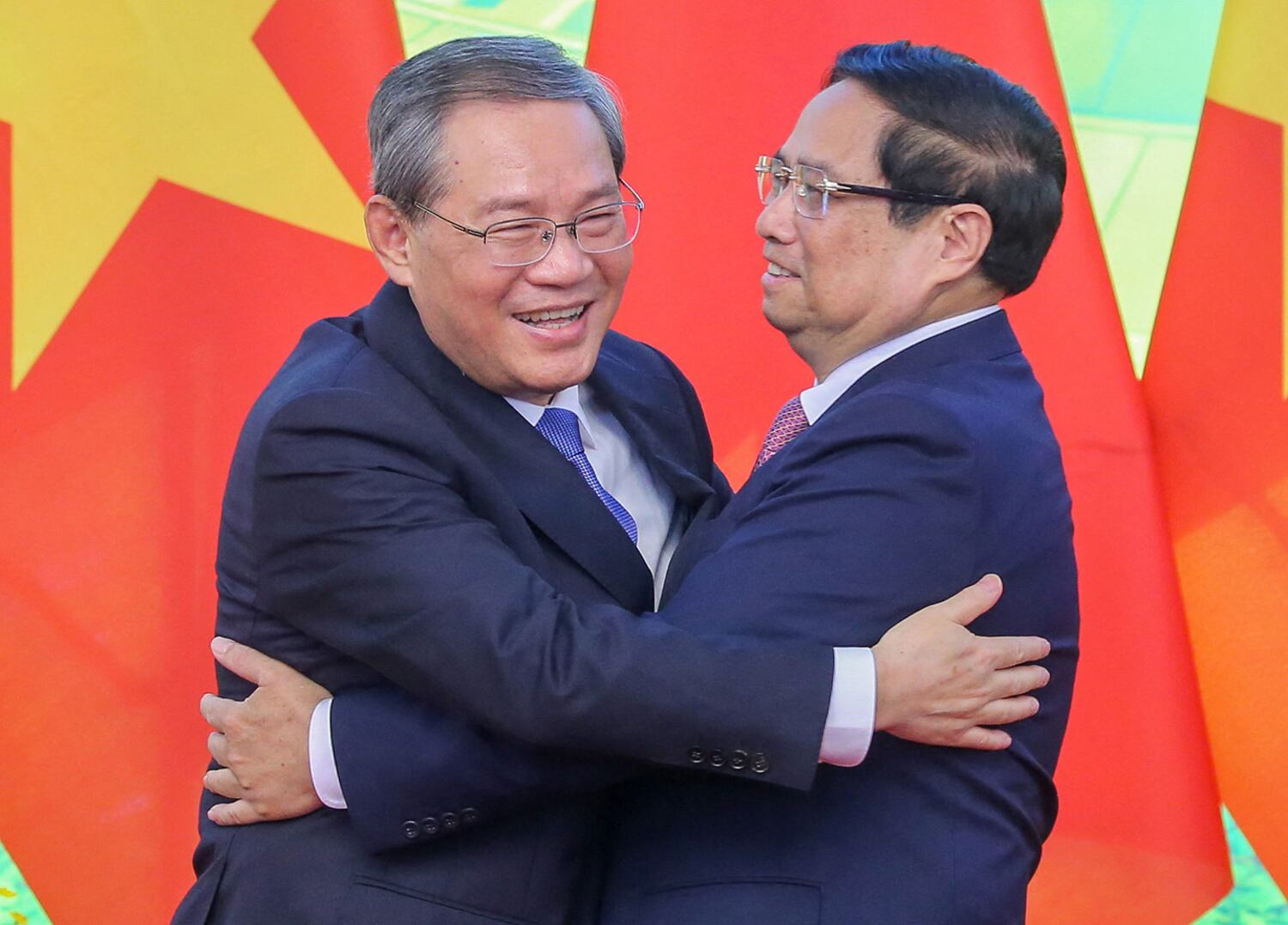 Vietnam's Prime Minister Pham Minh Chinh, right, and China's Premier Li Qiang hug as they pose for photos during a meeting in Hanoi on Oct. 13, 2024.