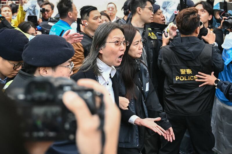 Police detain a woman outside the West Kowloon Magistrates' Court in Hong Kong on Nov. 19, 2024, as the city's largest national security trial drew to a close.