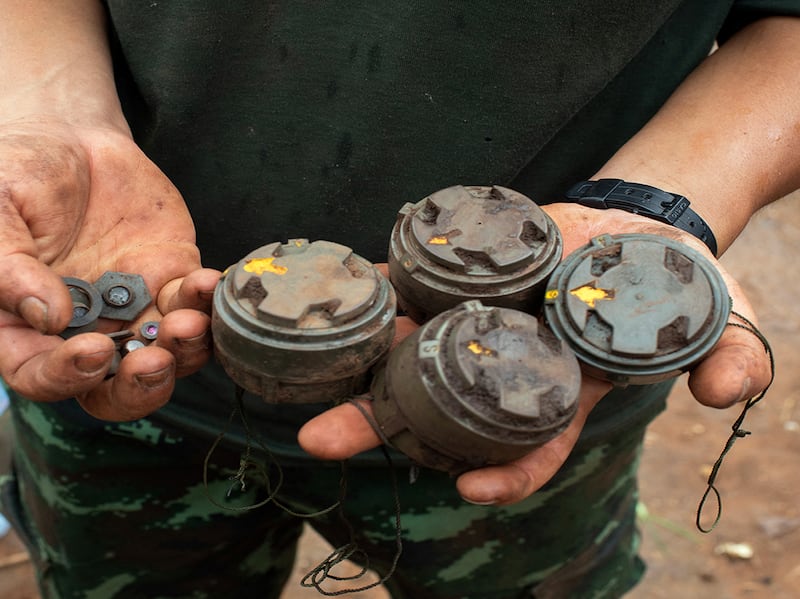 A member of the anti-junta Karenni Nationalities Defence Force holds landmines planted by the Myanmar military and removed during demining operations near Pekon township,  July 11, 2023.