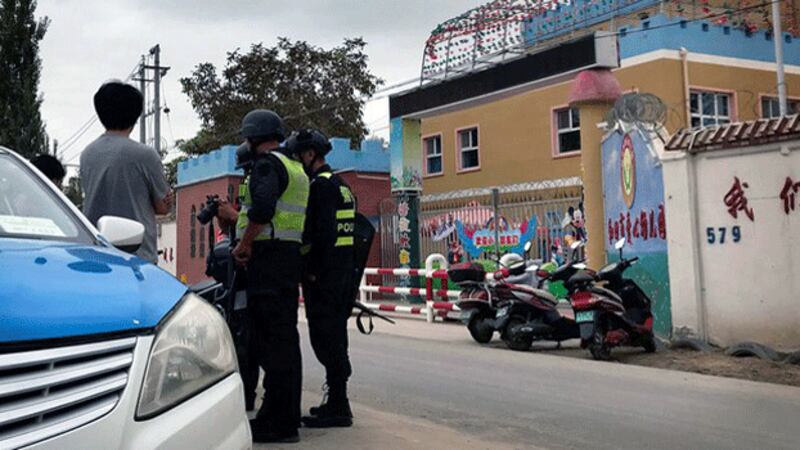 Police patrol a street alongside a school in the city of Hotan in northwestern China's Xinjiang region, Aug. 30, 2018. Credit: AP