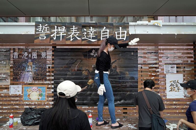 2020年9月29日，大学生在香港大学的“列侬墙”上张贴了民主宣传画。（美联社）