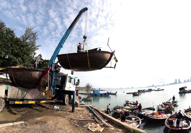 People move fishing boats to save place ahead of Typhoon Molave in Danang, Vietnam on Monday, Oct. 26, 2020. National agency forecasts the typhoon to hit Vietnam on Wednesday morning in the central region where 1.3 people could face evacuation. (Tran Le Lam/VNA via AP)