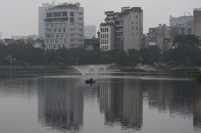 Người dân chèo thuyền câu cá trên một hồ ở Hà Nội.