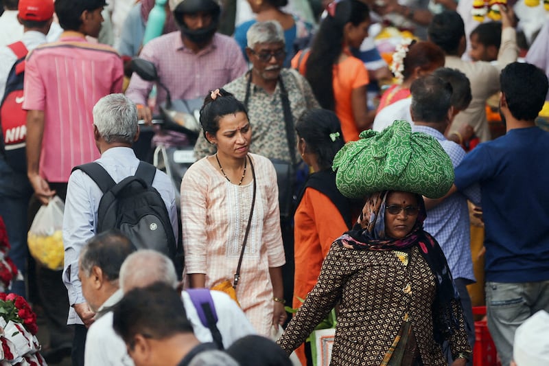 People walk through a crowded market in Mumbai, India, Dec. 22, 2022.