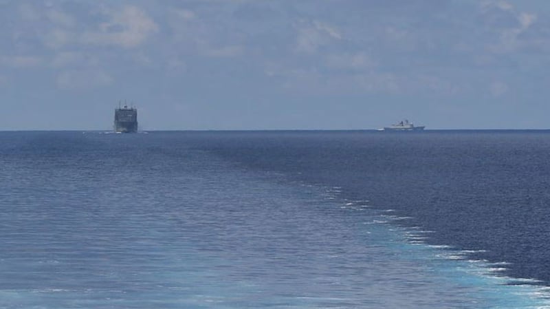 A photo taken from the littoral combat ship USS Montgomery, showing the USNS Cesar Chavez trailing it on the left, and a Chinese Navy warship on the right. 