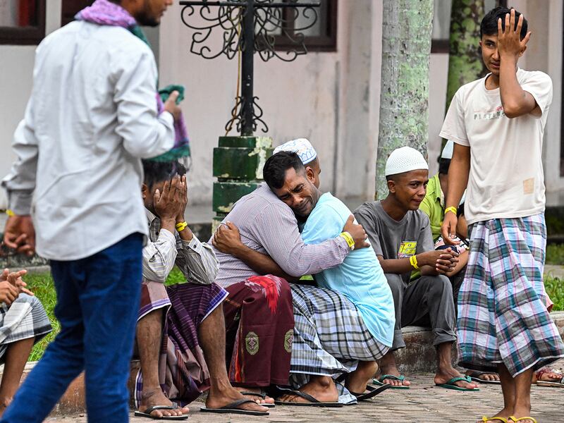 Rohingya refugees embrace each other after taking part in Eid al-Fitr prayers at a temporary shelter in Meulaboh, Indonesia,  April 10, 2024.