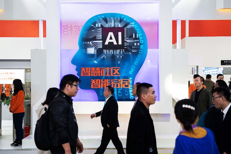 Visitors walk past a stand with AI security cameras using facial recognition technology at the 14th China International Exhibition on Public Safety and Security, in Beijing on Oct. 24, 2018.