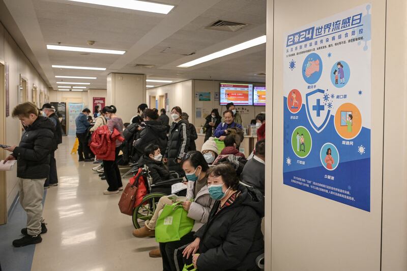 People wearing masks wait at an outpatient area of the respiratory department of a hospital in Beijing on Jan. 8, 2025.