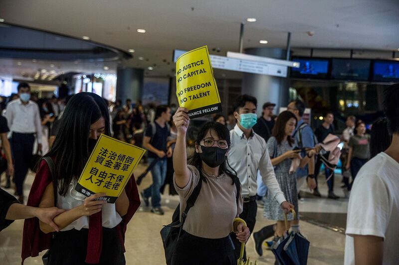 2019年8月1日，香港示威者手持“法治倾倒 资金著草 自由不保 人才走佬”等标语。（法新社）