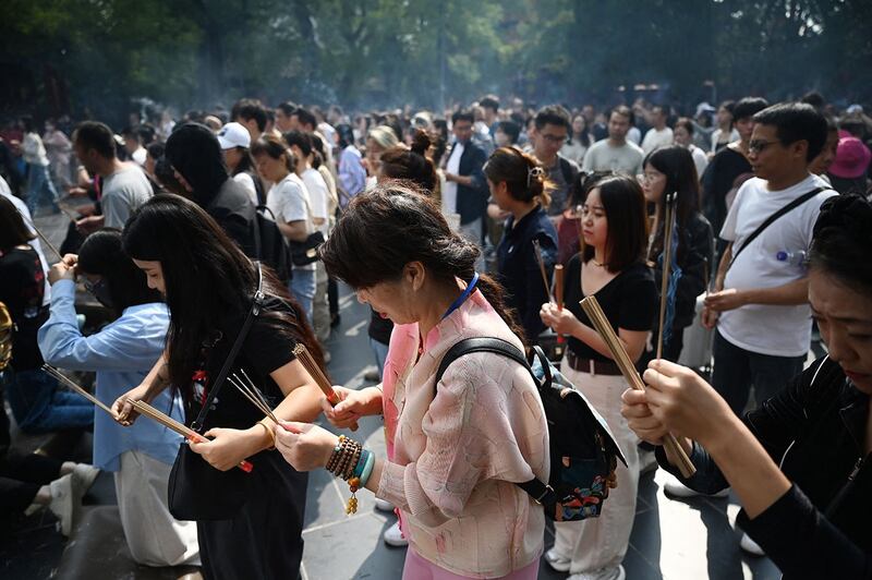 2024年9月17日，中秋节期间，人们在北京雍和宫焚香祈祷。（法新社）