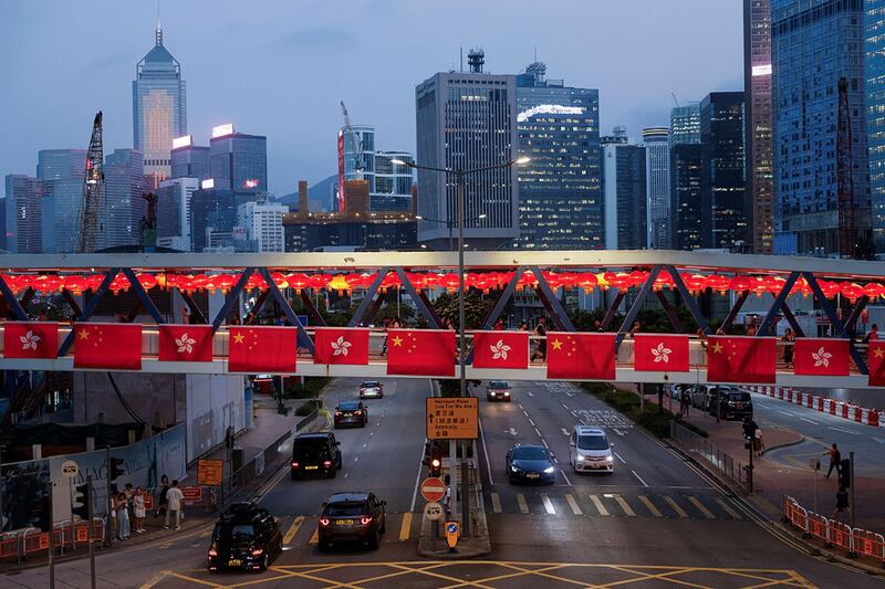 香港金融中心区，人行天桥上悬挂着中国国旗和香港区旗。（路透社）