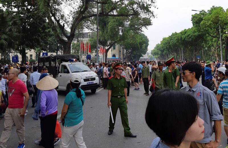 Vietnamese police watch over protesters during a demonstration near the Hoan Kiem Lake in Hanoi on June 10, 2018. (AFP)