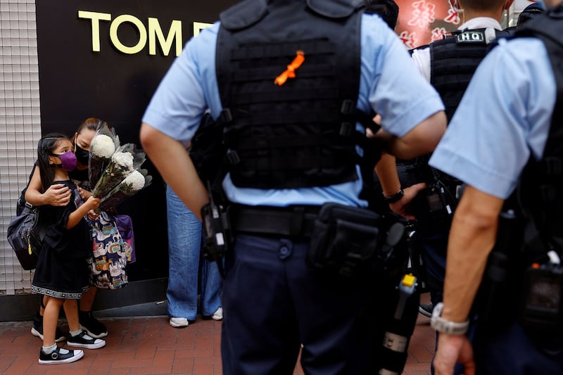 2021年7月2日，一名拿着鲜花的母子被香港警察拦下并搜查。( 路透社)