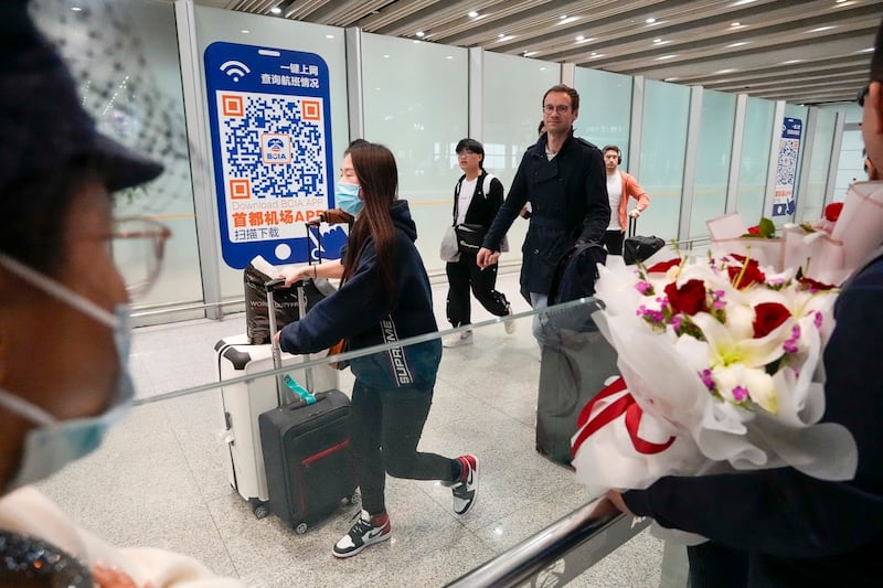 A foreigner walks out of an exit at the arrival hall of the Beijing Capital International Airport in Beijing, March 14, 2023. (Ng Han Guan/AP)