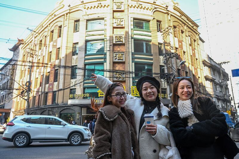 图为人们在上海黄河路拍照。受到热播电视剧"繁花"响，上海黄河路、和平饭店等成为游客热门打卡地，和平饭店销售额比2019年农历同期增长超过百分之六十。不过，当地人说，大部分人看热闹，没怎么消费。（法新社图片）