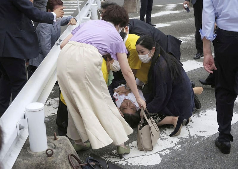 Former Japanese Prime Minister Shinzo Abe lies on the ground after being shot while campaigning in Nara, Japan, on July 8, 2022. (Kyodo via Reuters)