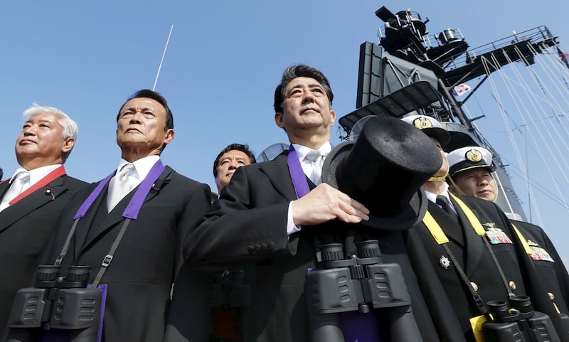 Japan's then-Prime Minister Shinzo Abe (center) reviews the Japan Maritime Self-Defence Force (JMSDF) fleet with at Sagami Bay, off Yokosuka, south of Tokyo in a file photo from Oct. 18, 2015. Credit: Reuters