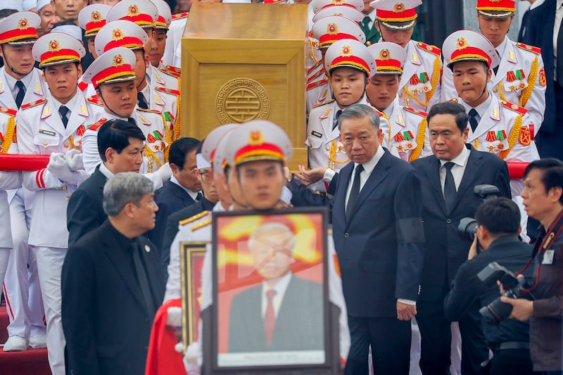 Chairman of the National Assembly of Vietnam Tran Thanh Man, right, Vietnam's President To Lam, second right , Vietnamese Prime Minister Pham Minh Chinh, second left and standing member of the Secretariat General Luong Cuong, left along with soldiers carry the coffin of late general secretary of the Communist Party Nguyen Phu Trong to an artillery cart at the National Funeral House in Hanoi, Vietnam, July 26, 2024. (Minh Hoang/AP)