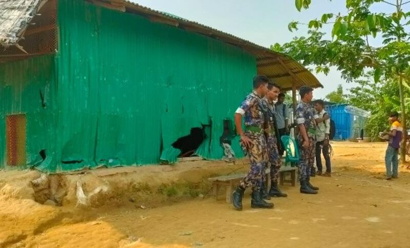 Police stand guard outside the Darul Ulum Nadwatul Ulama al-Islamia madrassa inside the Balukhali refugee camp in Ukhia, Cox's Bazar, Bangladesh, where at least six Rohingya were killed in a pre-dawn attack, Oct. 22, 2021. Credit: BenarNews