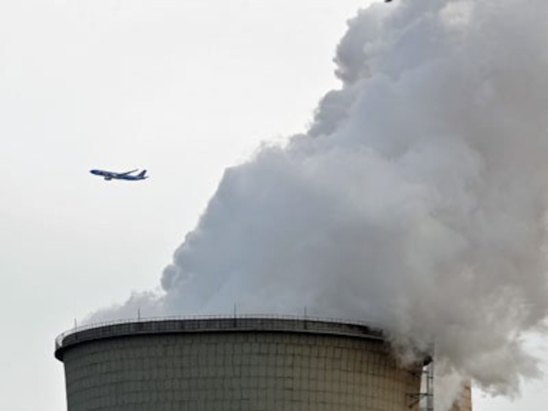 A passenger jet flies past steam and white smoke emitted by a coal-fired power plant in Beijing, China, Feb. 28, 2017. 