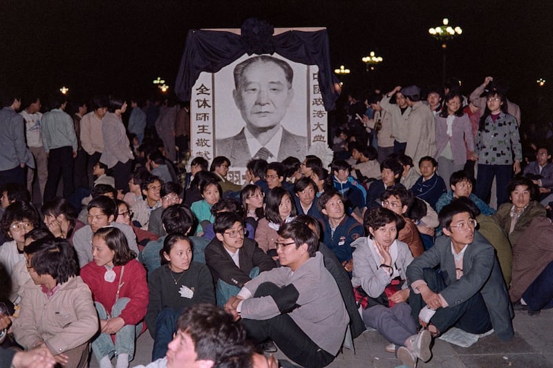 1989年4月22日晚，北京各高校的数万名学生在天安门广场彻夜等候，为胡耀邦先生送最后一程。（法新社）