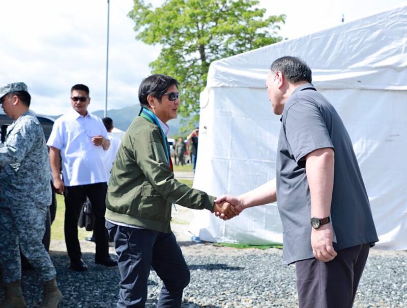 Philippine President Ferdinand Marcos Jr. (left) is greeted by Defense Secretary Gilberto Teodoro Jr. as he arrives to watch drills with Australian and U.S. troops in San Antonio town in Zambales, Philippines, Aug. 25, 2023. Credit: Handout photo/Philippines Department of National Defense