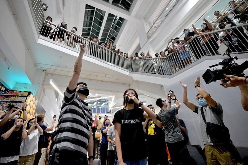 Apple Daily employees, executive editor in chief Lam Man-Chung (L) and deputy chief editor Chan Pui-Man (C) cheer each other after the paper goes to print for the last time. (AFP)