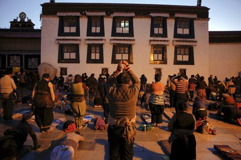 Pilgrims pray outside the Jokhang Temple in central Lhasa, capital of western China's Tibet Autonomous Region, Nov. 20, 2015. Every day thousands of Tibetans visit and pray at the temple, considered one of the most sacred places of Tibetan Buddhism. (Damir Sagolj/Reuters)