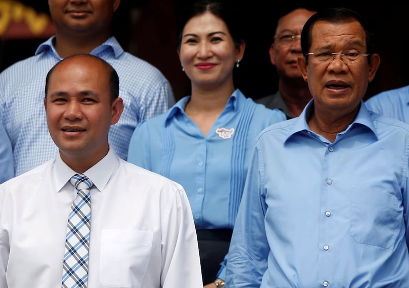 Cambodia's Prime Minister Hun Sen, right, and his son Hun Many attend a campaign event to break the world record for longest woven cotton scarf in Phnom Penh, June 7, 2018. (Samrang Pring/Reuters)