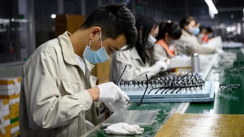 受疫情影响，2月份中国制造业采购经理指数（PMI）为35.7%，比上月下降14.3个百分点。图为2020年2月28日在温州一家眼镜公司，工人戴着口罩抛光眼镜架。（法新社）