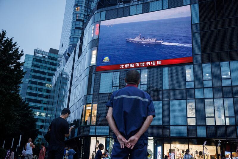 A man watches a CCTV news broadcast about joint military operations near Taiwan by the Chinese People's Liberation Army's Eastern Theatre Command, at a shopping center in Beijing, 2022. Credit: Thomas Peter/Reuters