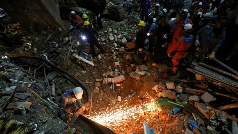 Rescue workers search for victims in the debris after a Chinese-owned, seven-storey building collapsed in Cambodia's Sihanoukville on June 22, 2019. 