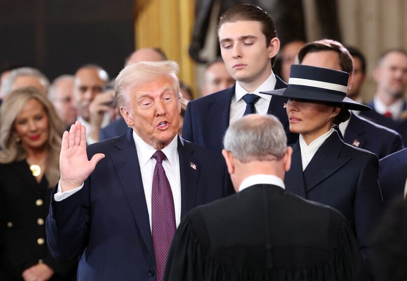 U.S. President Donald Trump takes the oath as Barron  and Melania Trump look on at the Rotunda of the U.S. Capitol in Washington, Jan. 20, 2025.