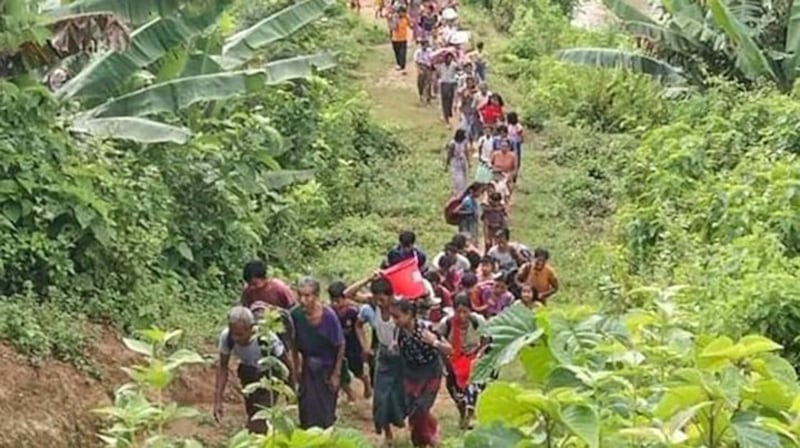 Refugees in Matupi township in Myanmar's Chin state make their way through the woods in 2022. Credit: Matupi Revolution News