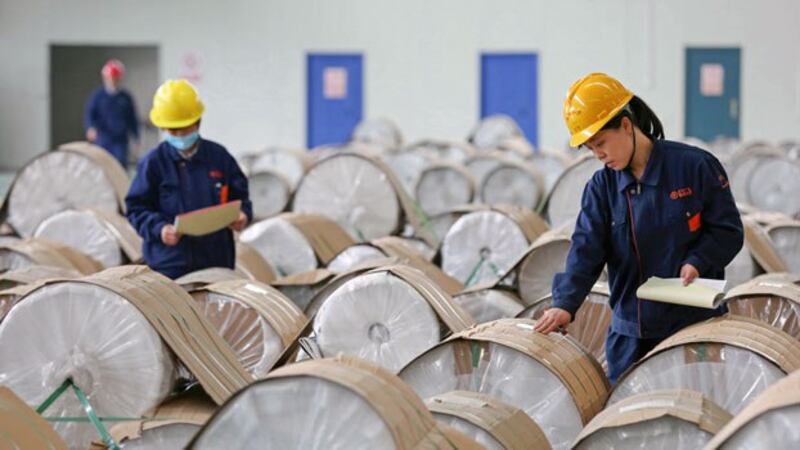 Chinese workers check rolls of sheet aluminum at a factory in Huaibei, eastern China's Anhui province, April 25, 2019.