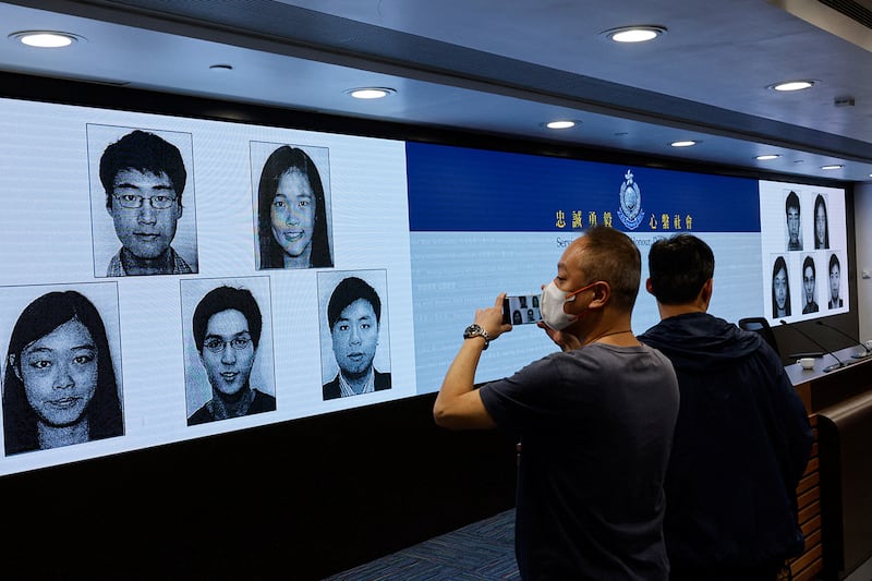 Images of activists Simon Cheng, Frances Hui, Joey Siu, Johnny Fok and Tony Choi are displayed during a press conference to issue arrest warrants in Hong Kong, Dec. 14, 2023.