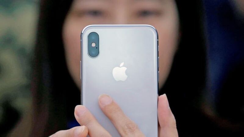 A Chinese woman uses a new iPhone X during a presentation for the media in Beijing, Oct. 31, 2017. 