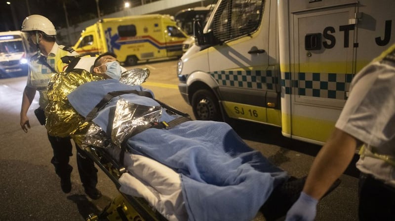 A protester is taken away on a stretcher outside the Hong Kong Polytechnic University campus in the Hung Hom district of Hong Kong, Nov. 19, 2019. 