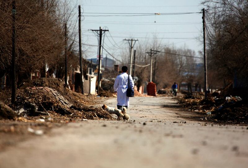 A doctor walks along a road through the village of Jianhua, located on the outskirts of Shuangcheng in Heilongjiang province, China, March 29, 2011. Credit: Reuters