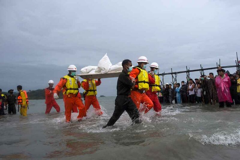 Rescue workers carry a body at Sanhlan village in Dawei on June 8, 2017, after a Myanmar military plane crashed in the Andaman Sea off southern Myanmar.