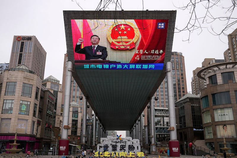 2023年3月11日，北京街头的大屏幕显示习近平在北京人大会堂举行的全国人大会议上宣誓第三次连任国家主席。（美联社）